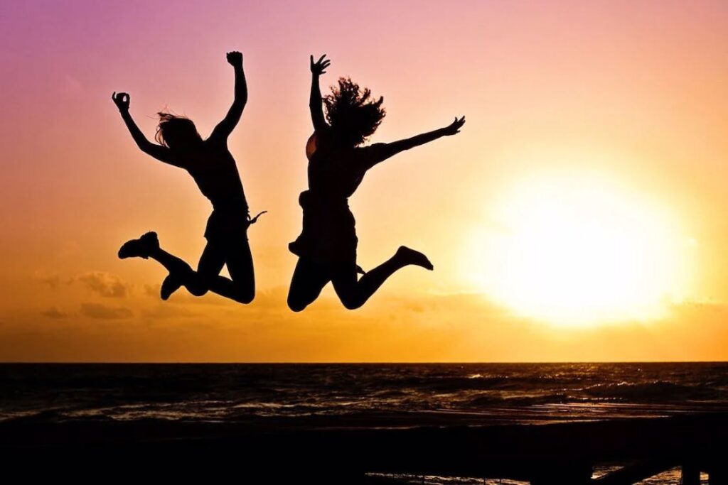 Silhouette of two women jumping in the sunset