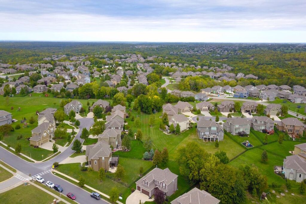 Drone shot of a neighborhood with similar looking gray roofs