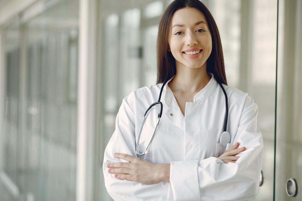 A female doctor in medical uniform with a stethoscope standing in clinic