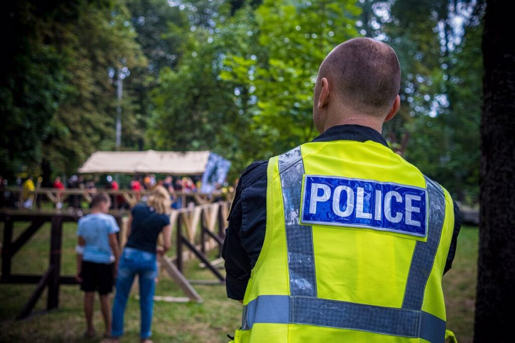 Police officer wearing a yellow vest as he observes a local event