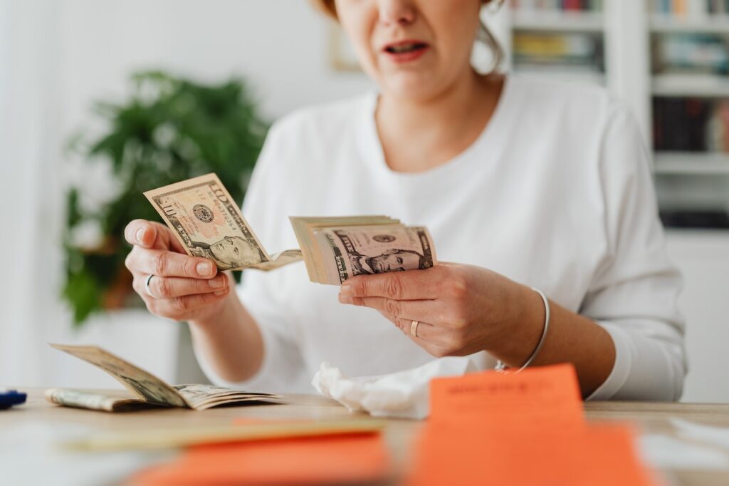 A woman wearing white long sleeves counting money in the office