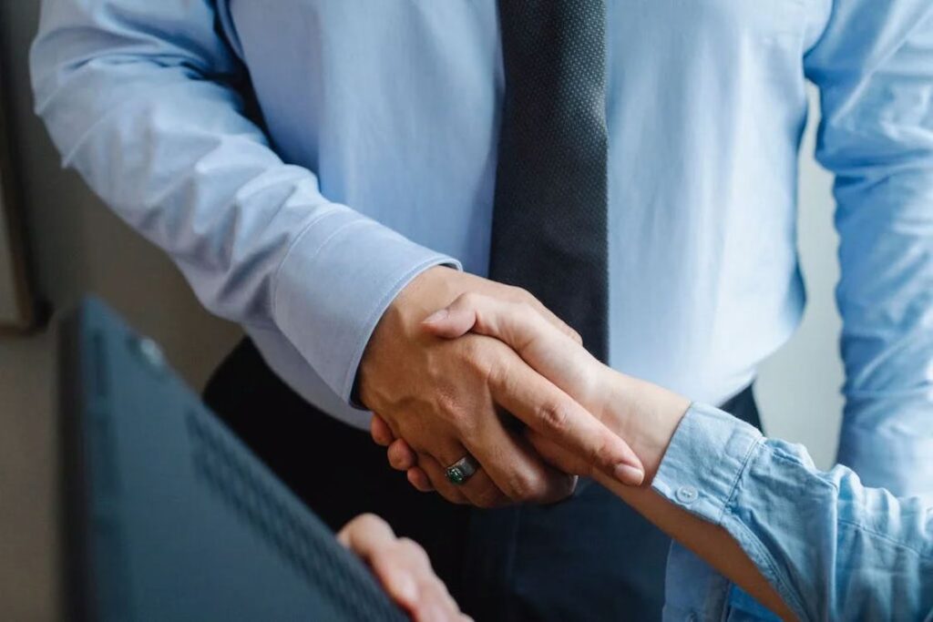 Man in a suit shaking hands after a meeting with someone