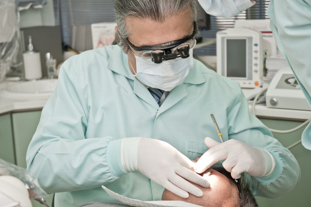 A dentist wearing a uniform performing dental care to a patient