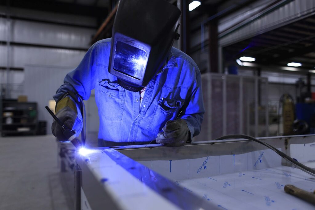 A person using protective gear while welding a stainless steel