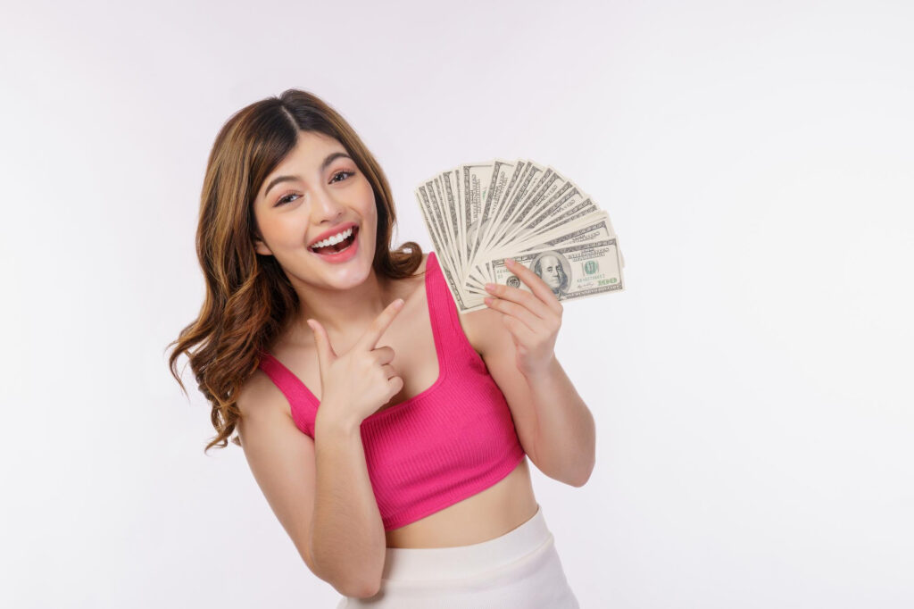 A woman pointing a pile of dollar bills holding in her right arm