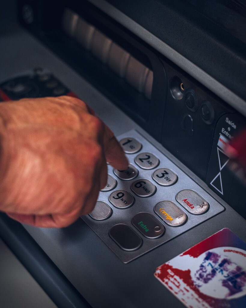 An image of an ATM machine keypad with hands typing