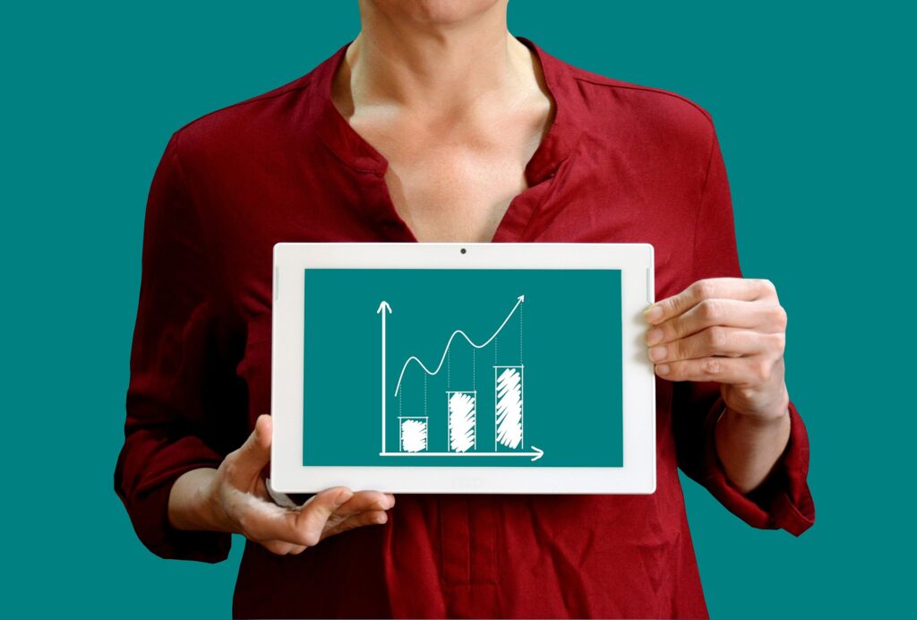 A woman in red holding a chart investment graph