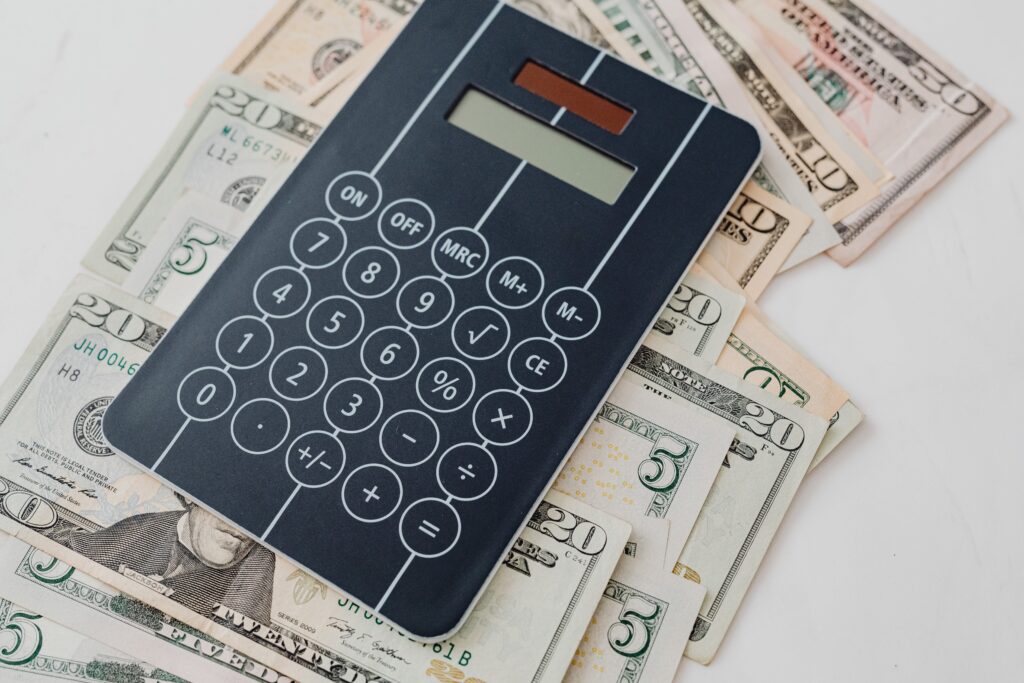 A sleek calculator on top of dollar bills