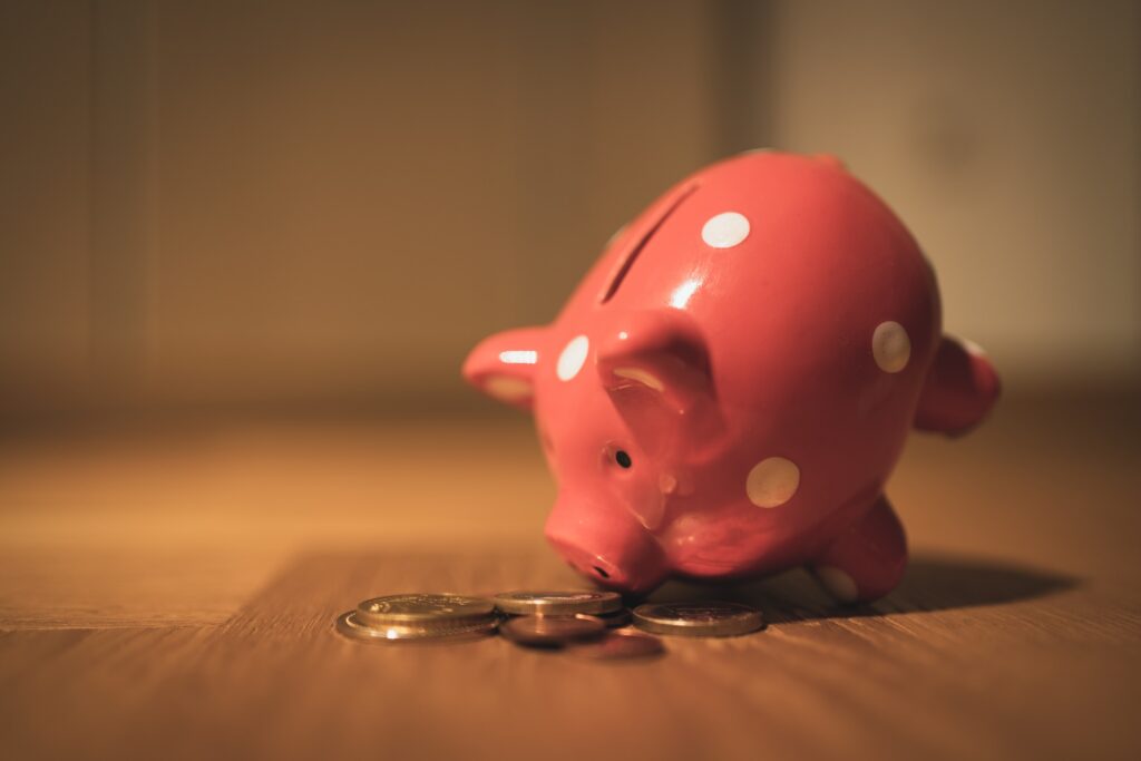 A pink piggybank with some coins