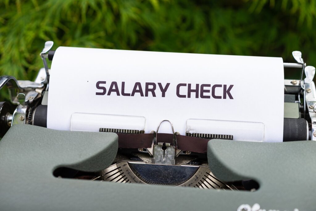 An image of a typewriter with a bondpaper that says salary check