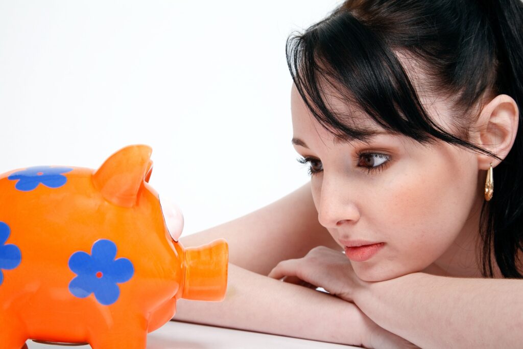 A woman looking at an orange with blue flowers piggybank