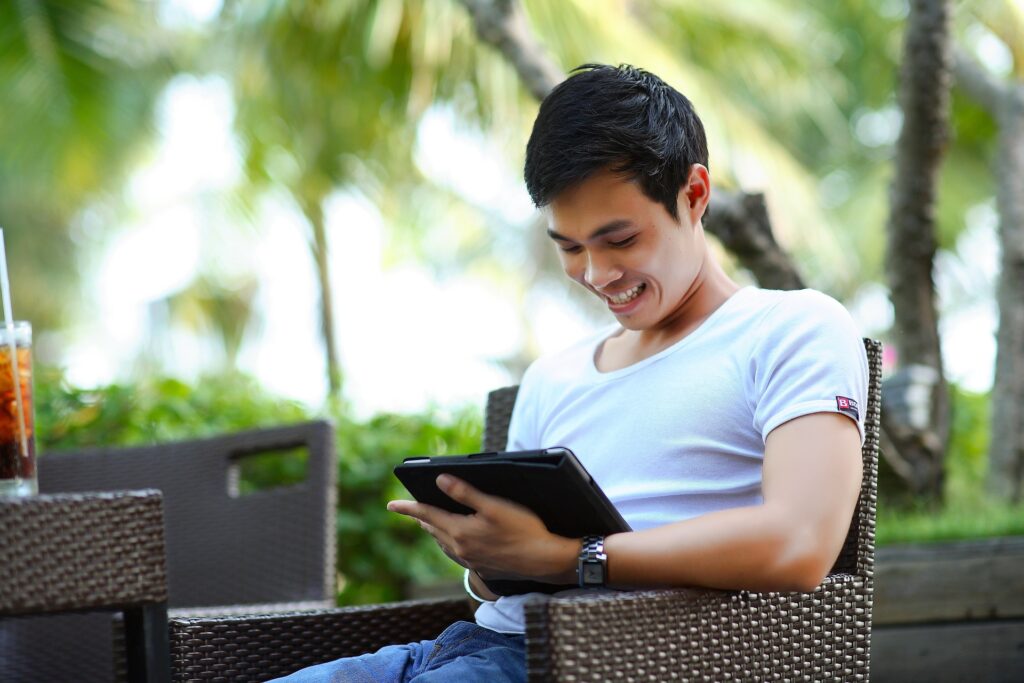 An image of a man sitting holding a tablet