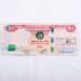 A 100 United Arab Emirates dirham bill was placed on a white surface